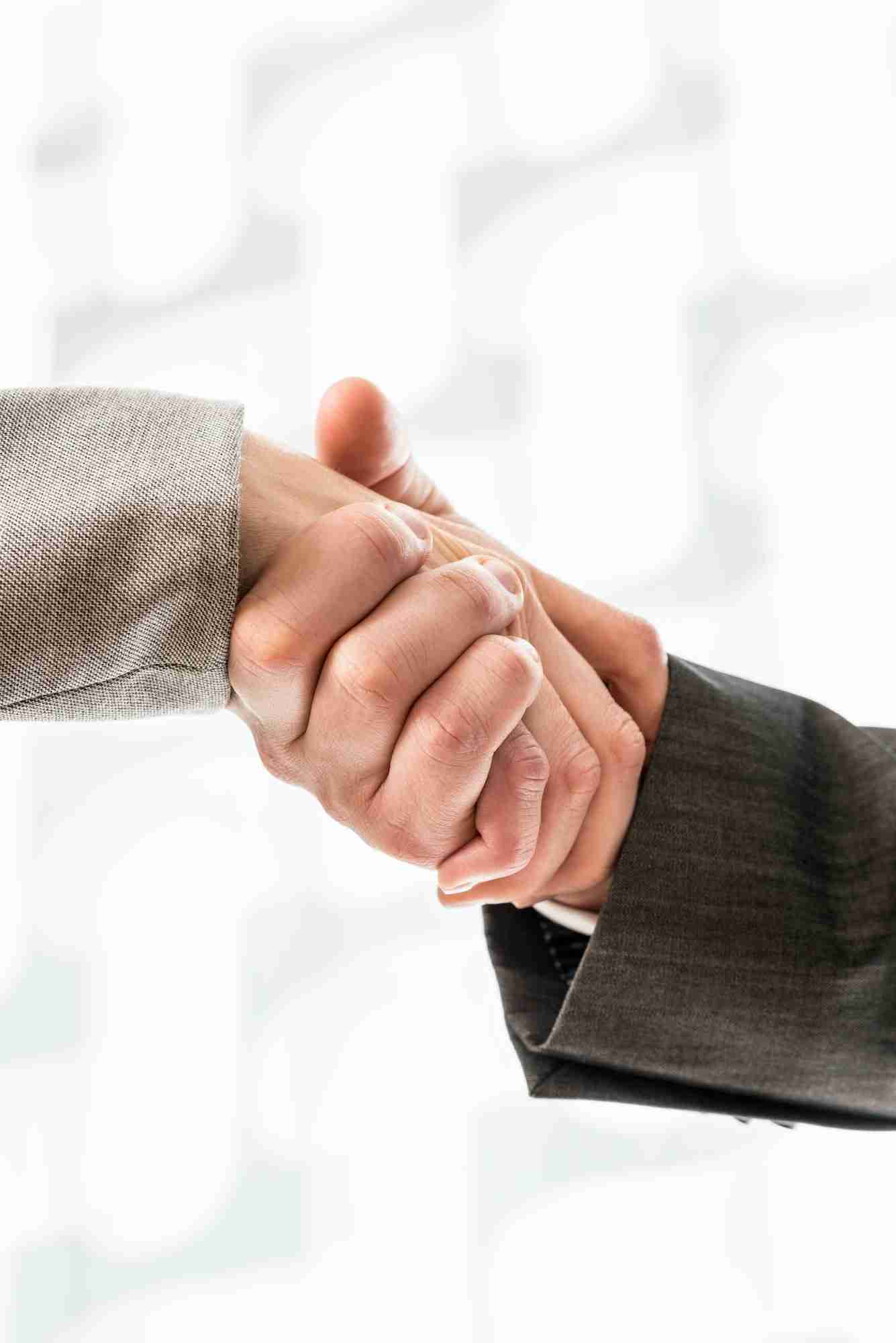 Businessman and businesswoman in suits shaking hands