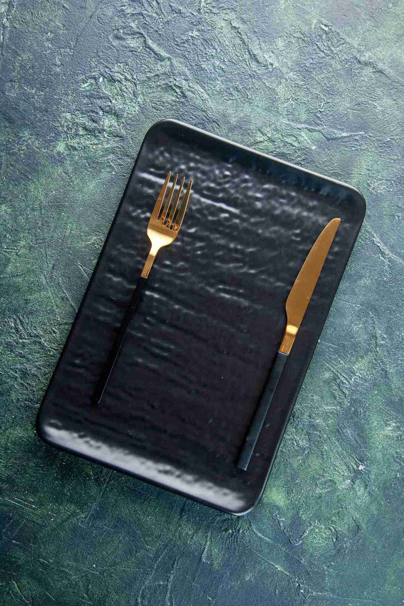 top view black plate with golden fork and knife on dark background utencil color dinner cutlery